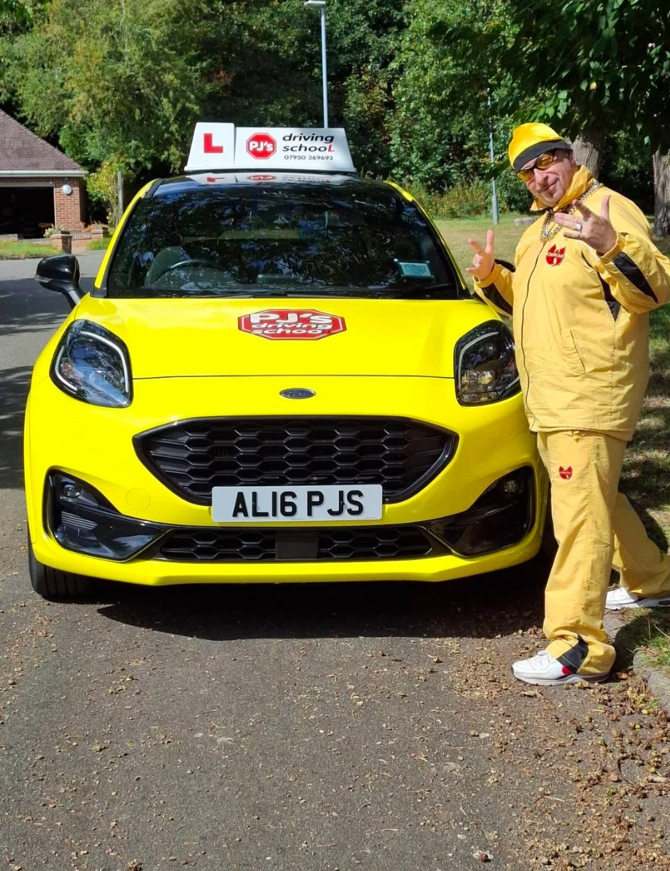 PJ beside the bright yellow PJ's Driving School learner car