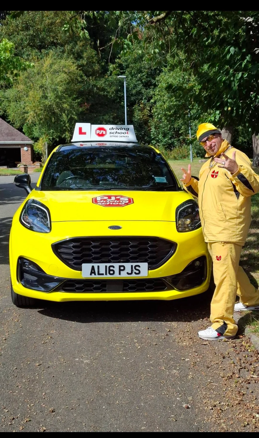 PJ beside the yellow and black driving school car