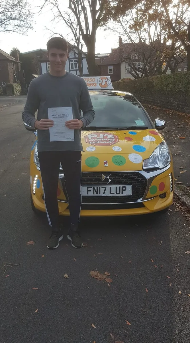 Learner celebrating a driving test pass beside PJ's lesson car