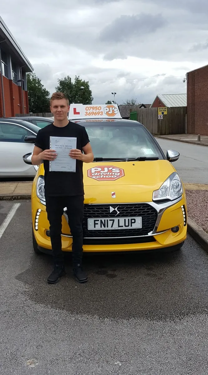 Learner celebrating a driving test pass beside PJ's lesson car
