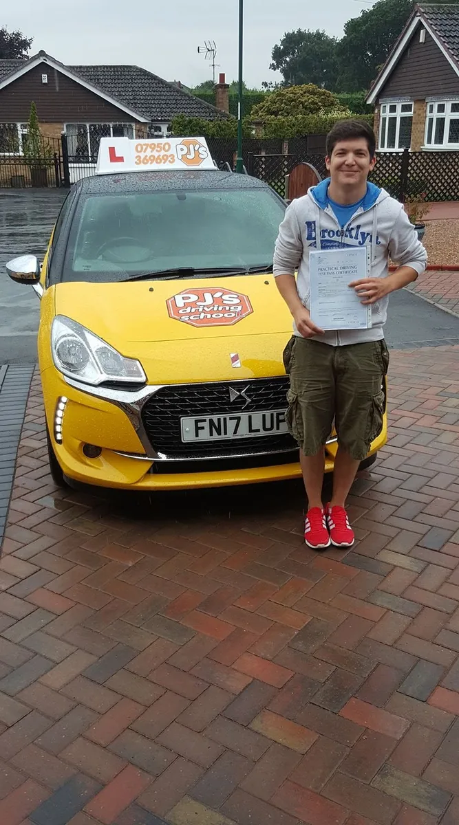 Learner celebrating a driving test pass beside PJ's lesson car