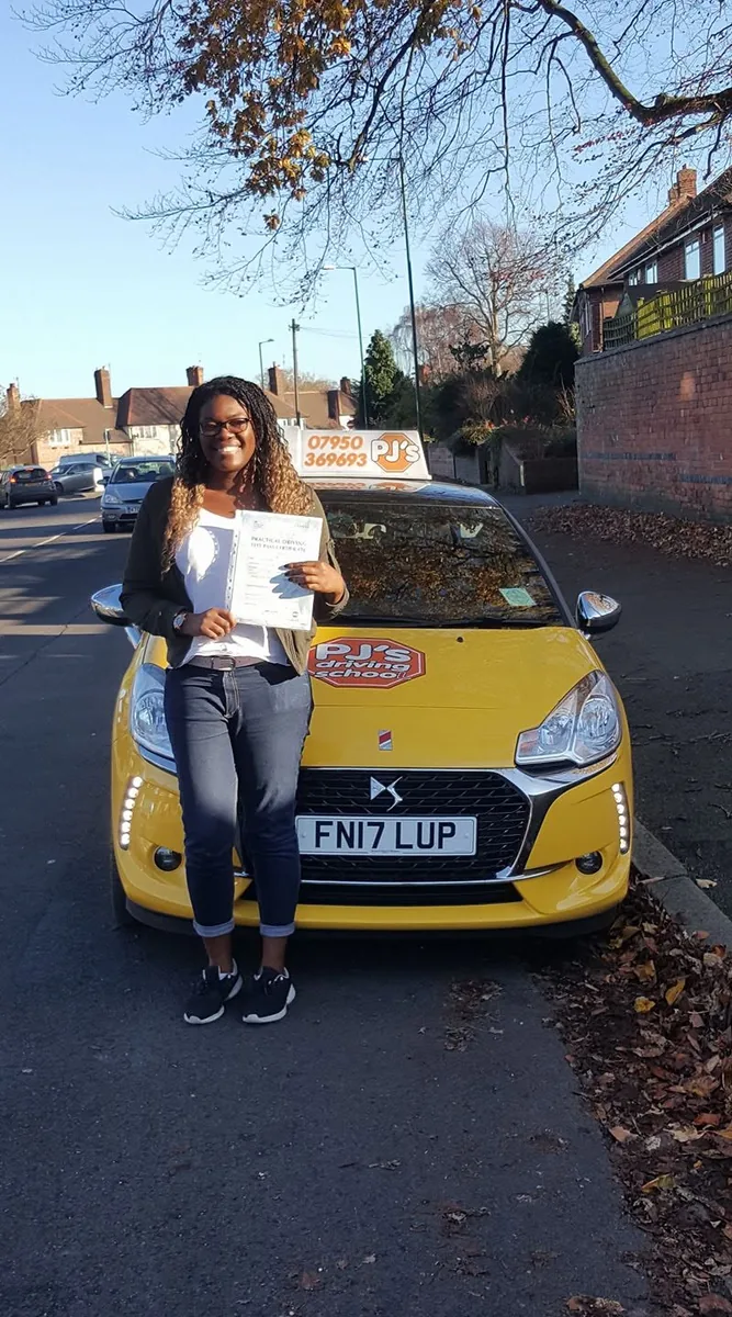 Learner celebrating a driving test pass beside PJ's lesson car