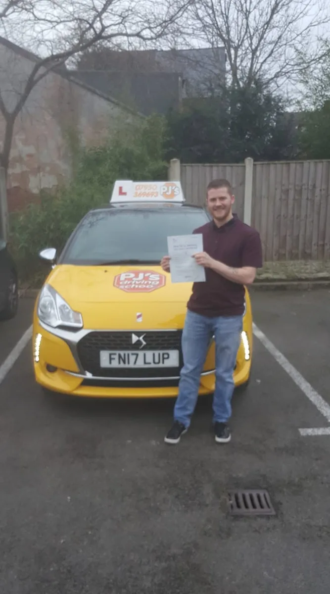 Learner celebrating a driving test pass beside PJ's lesson car