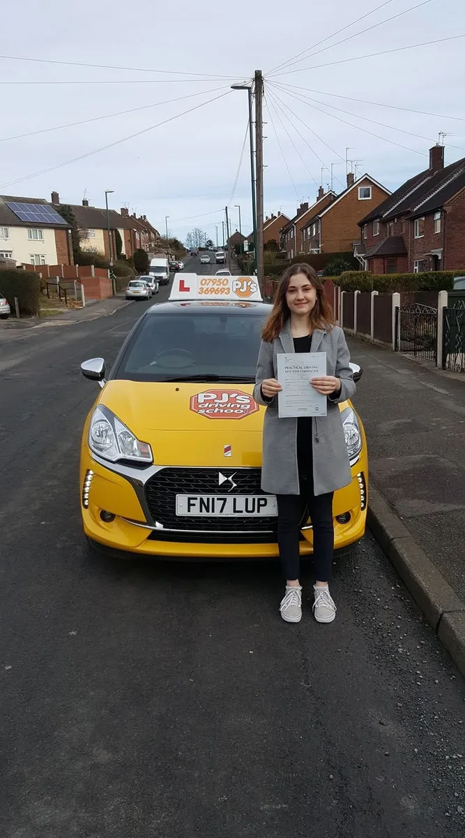 Learner celebrating a driving test pass beside PJ's lesson car