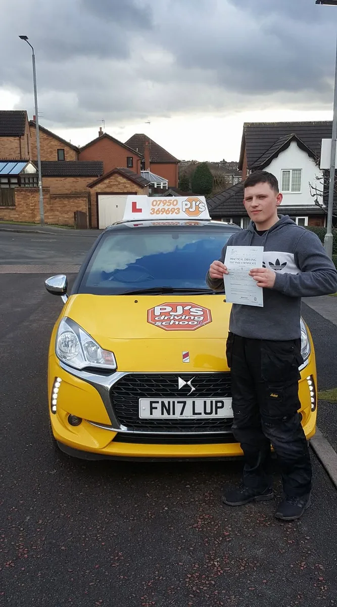 Learner celebrating a driving test pass beside PJ's lesson car