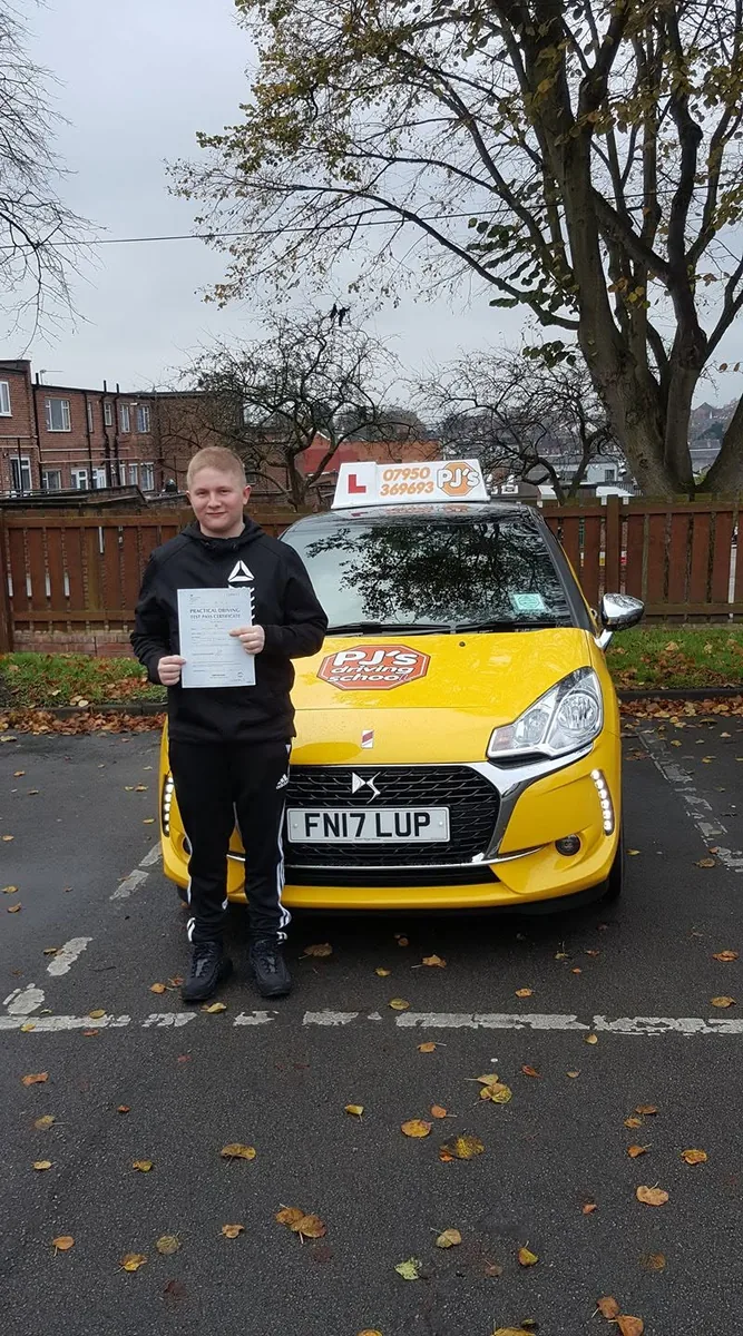 Learner celebrating a driving test pass beside PJ's lesson car
