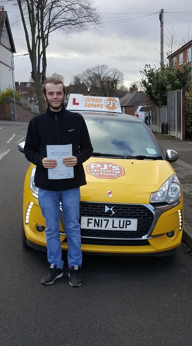 Learner celebrating a driving test pass beside PJ's lesson car
