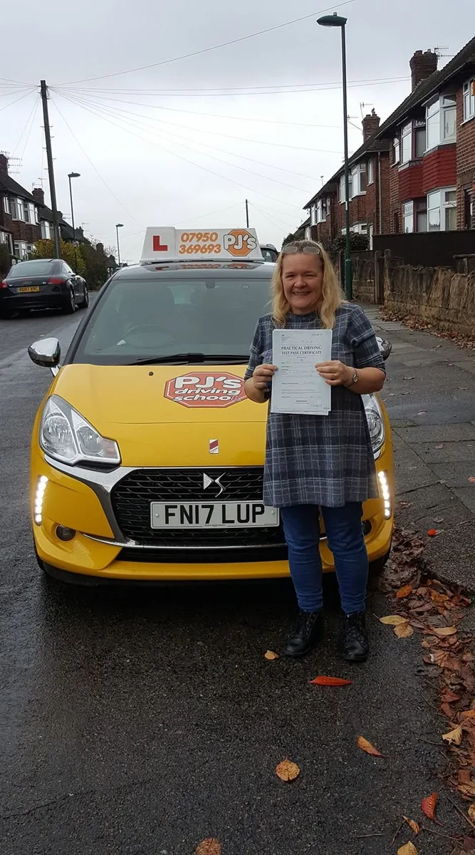 Learner celebrating a driving test pass beside PJ's lesson car