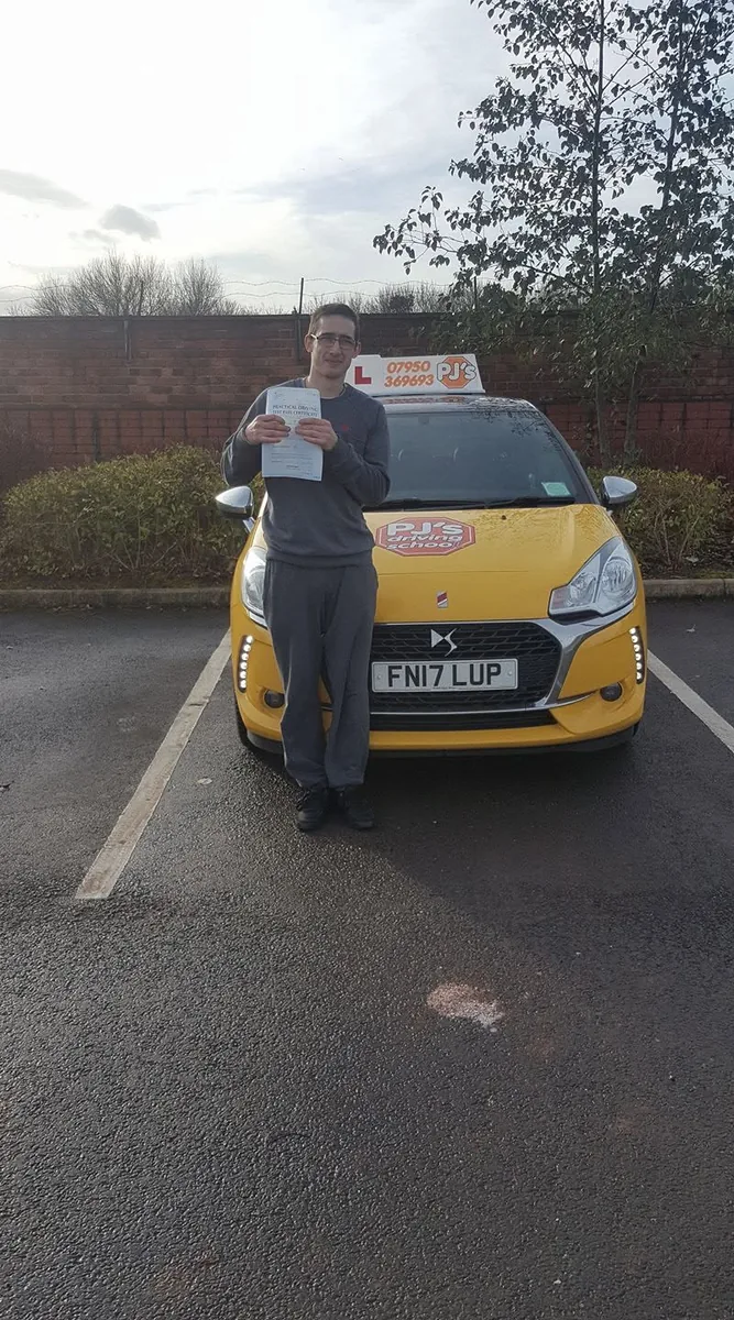 Learner celebrating a driving test pass beside PJ's lesson car