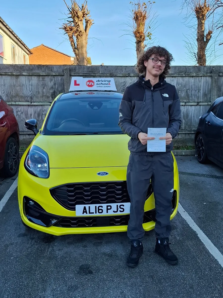 Learner celebrating a driving test pass beside PJ's lesson car