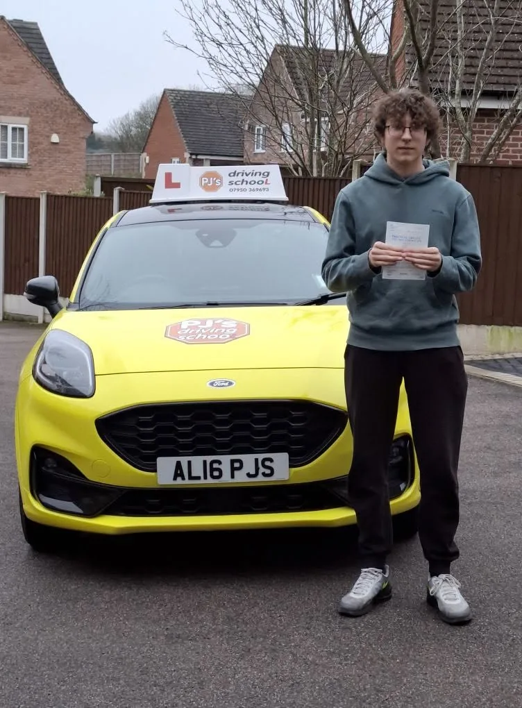 Learner celebrating a driving test pass beside PJ's lesson car