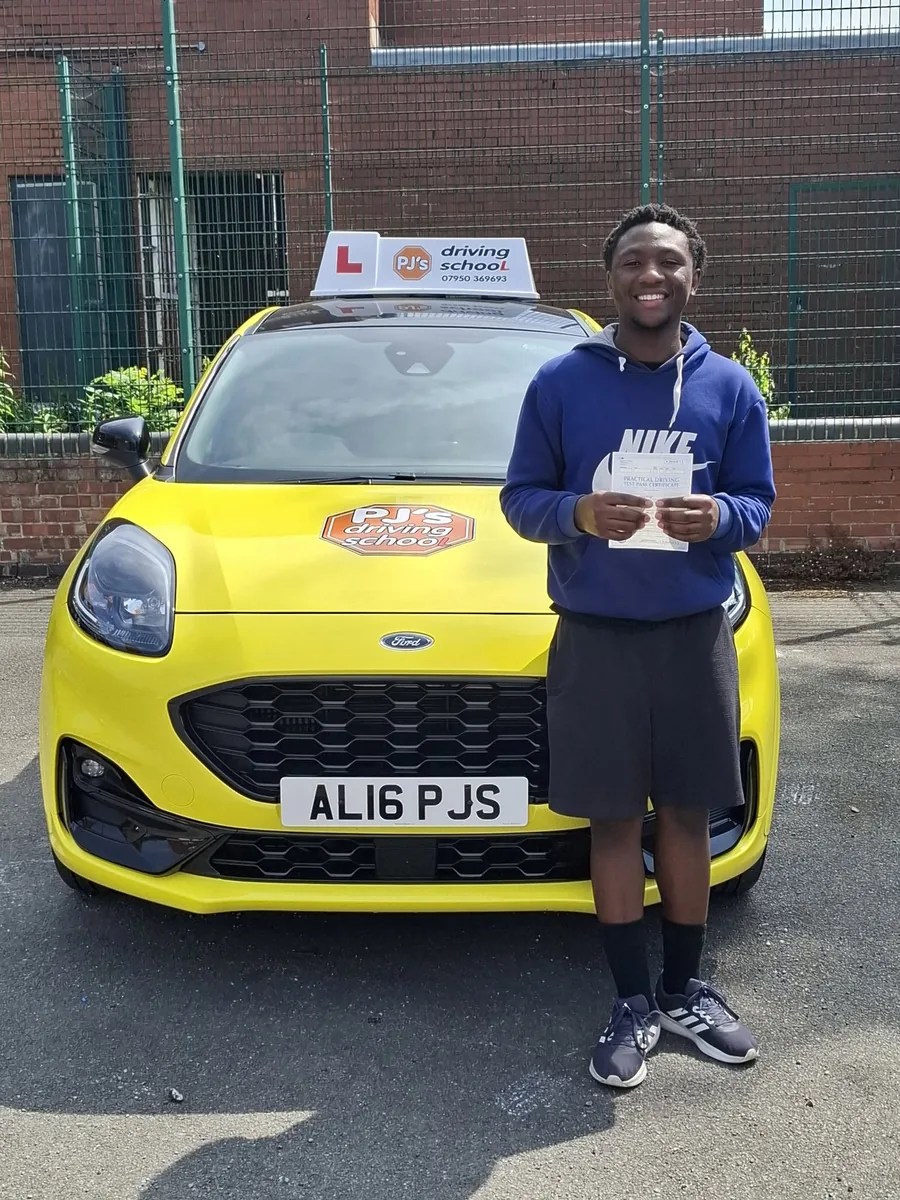 Learner celebrating a driving test pass beside PJ's lesson car