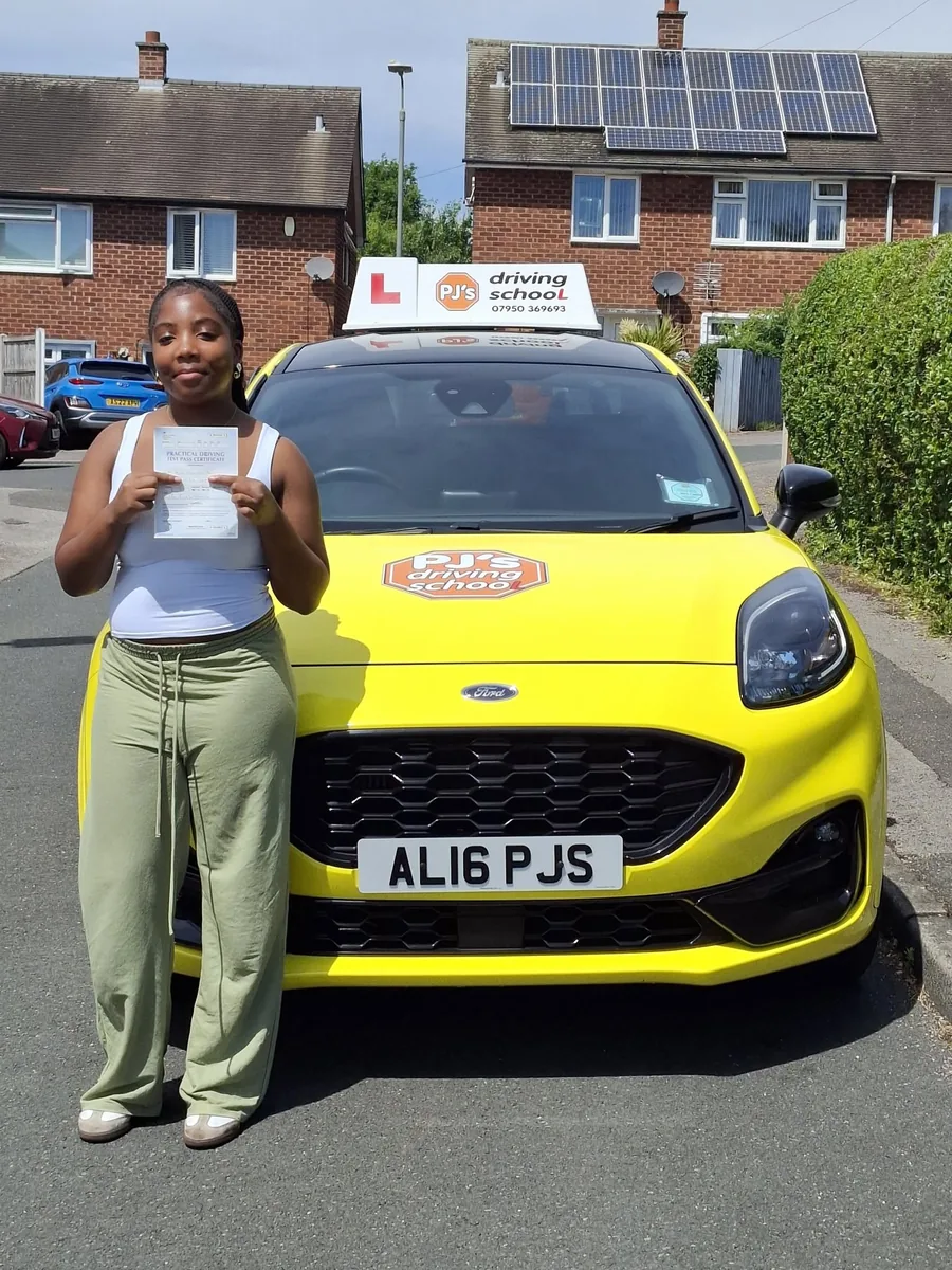 Learner celebrating a driving test pass beside PJ's lesson car